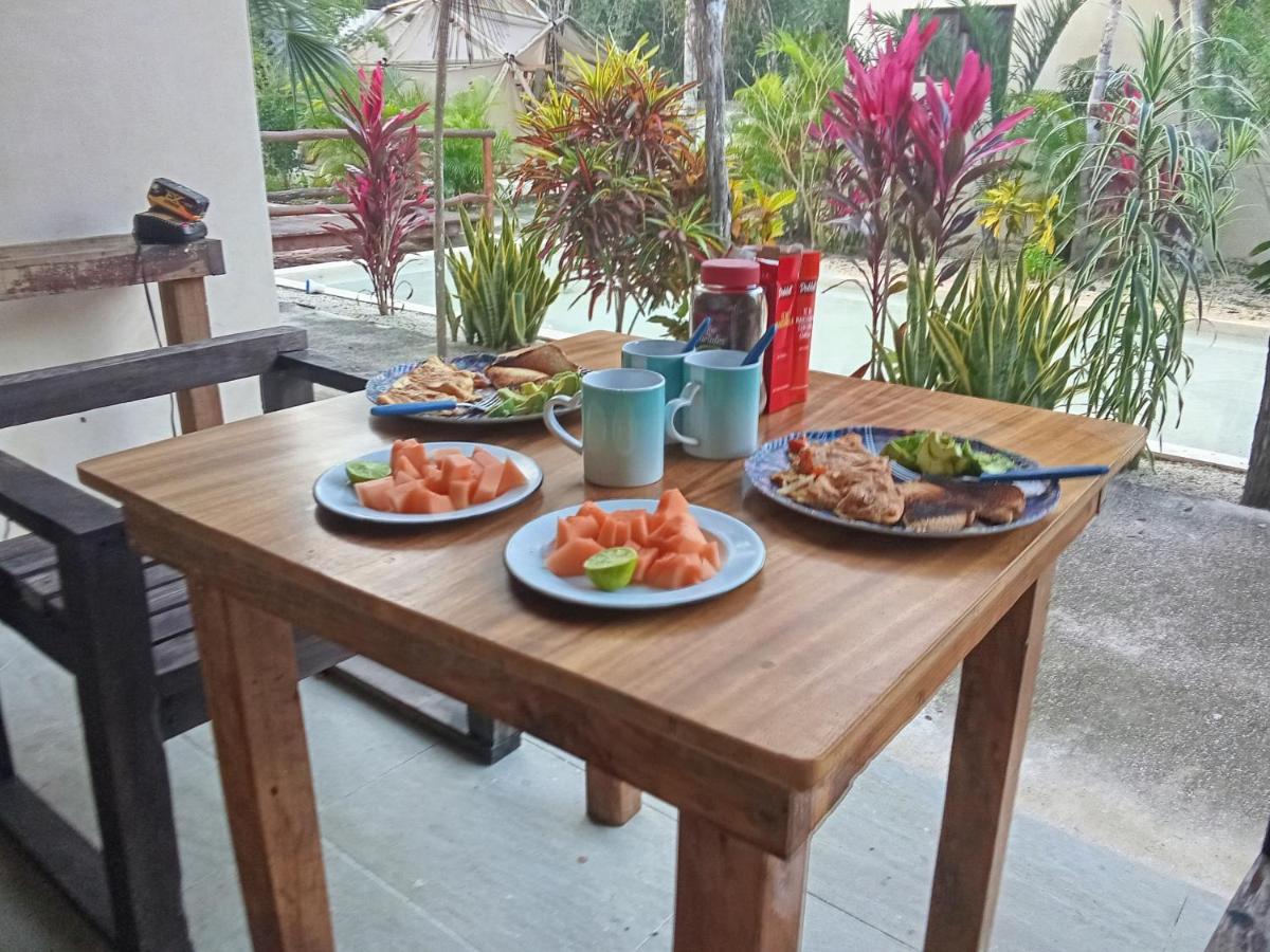 Desayuno servido en una mesa del jardín de Villas Ahal, entre plantas tropicales